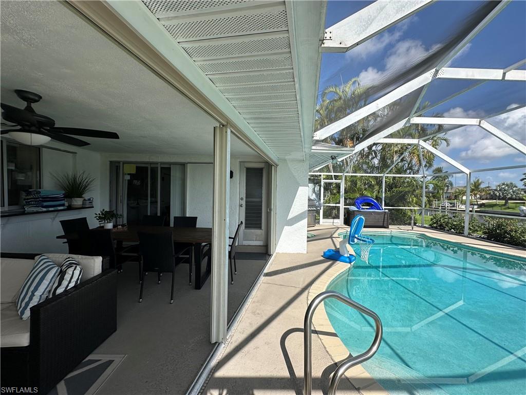 View of swimming pool featuring a lanai, a patio area, and ceiling fan