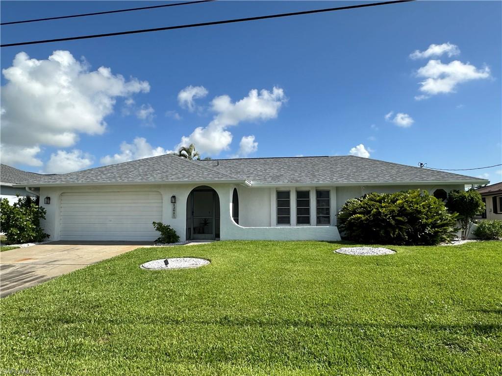 Ranch-style home with a garage and a front lawn