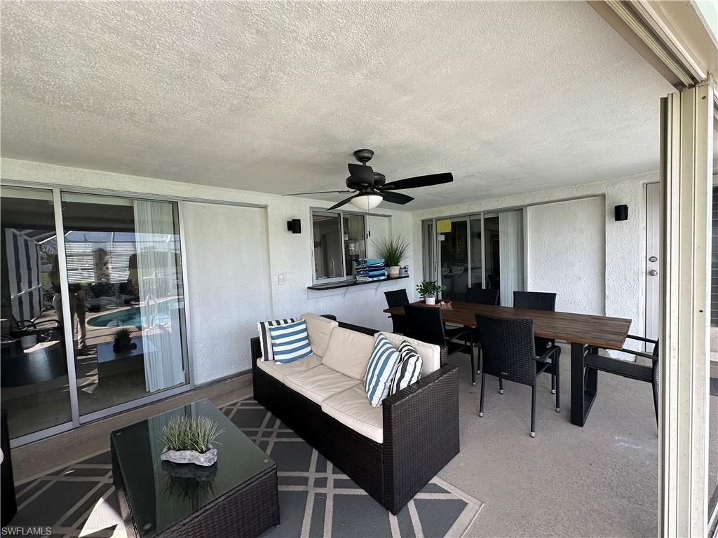 View of patio with an outdoor hangout area and ceiling fan