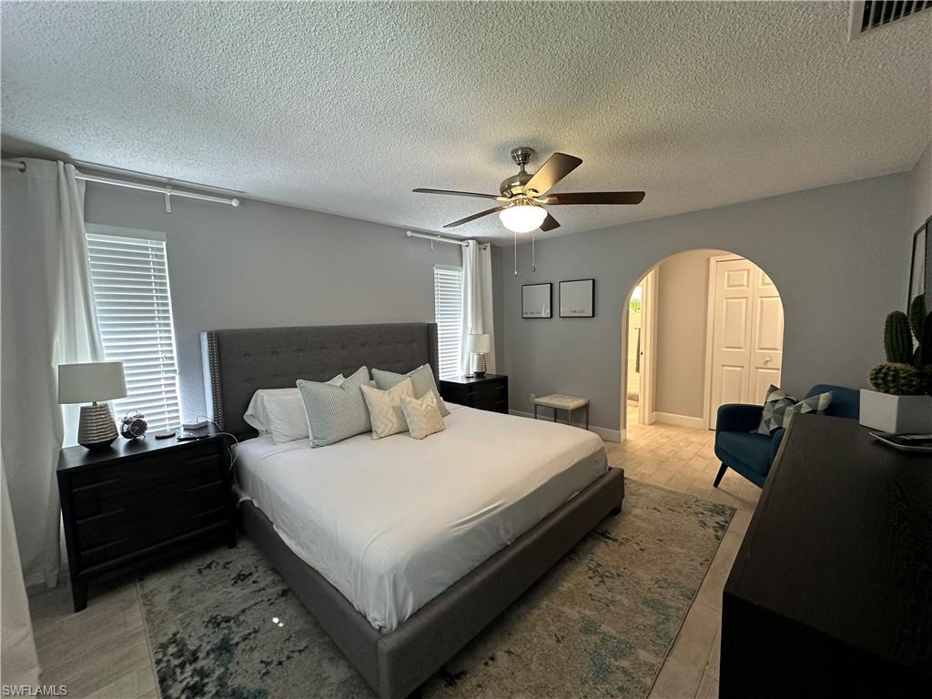 Bedroom featuring tile patterned flooring, a textured ceiling, and ceiling fan