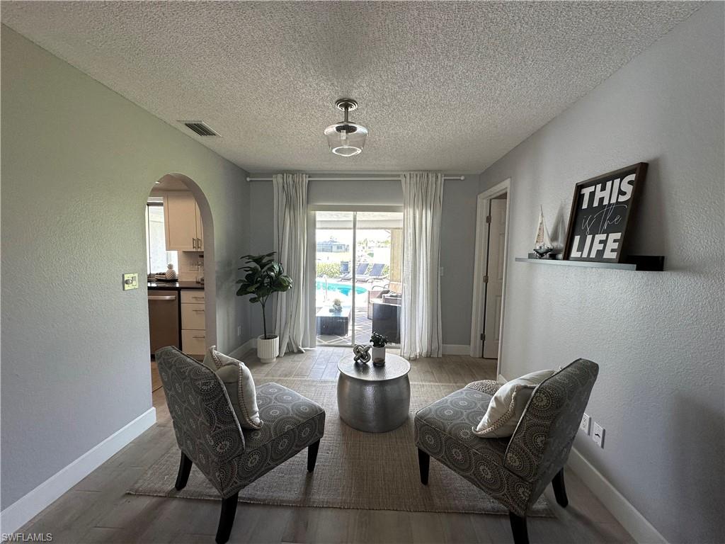 Living area featuring light wood-type flooring and a textured ceiling