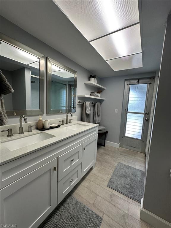 Bathroom with dual vanity and hardwood / wood-style floors