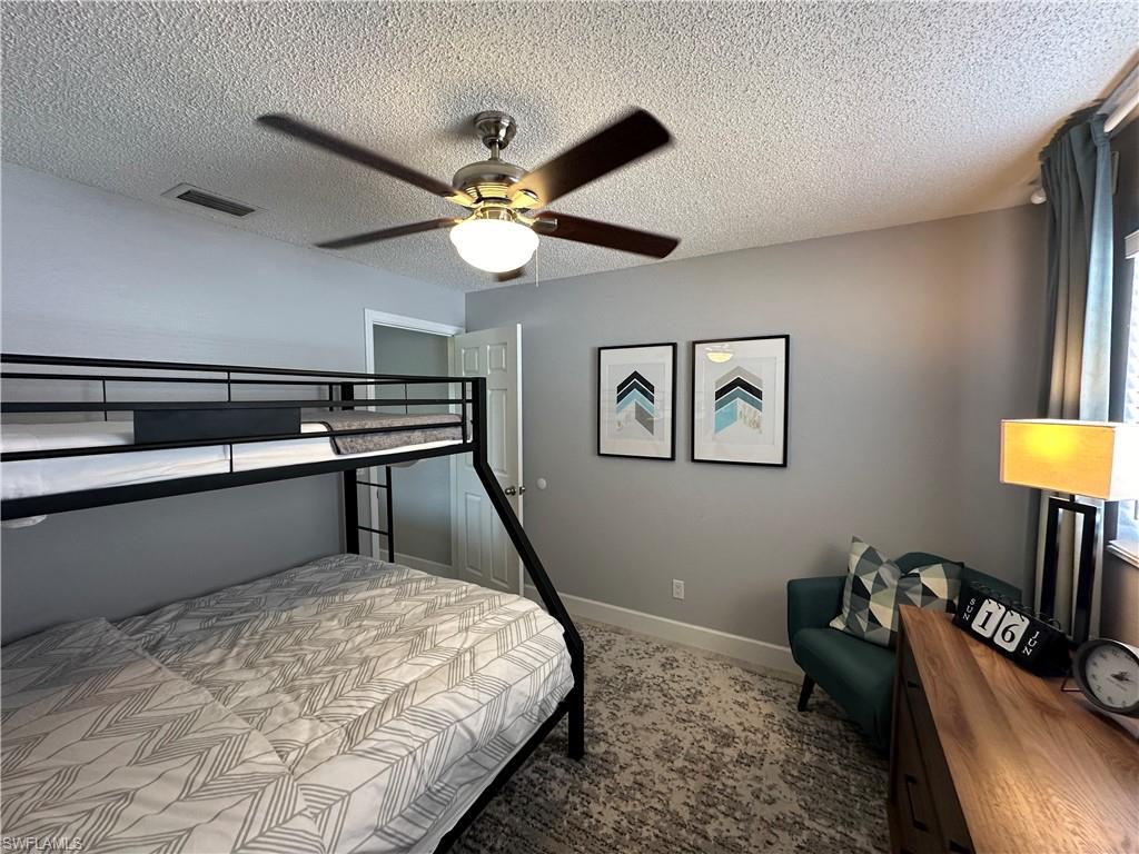 Bedroom with a textured ceiling and ceiling fan