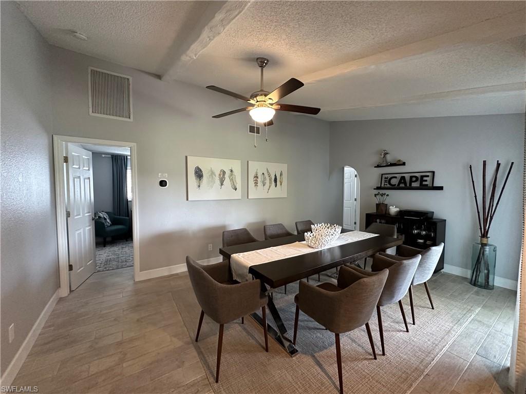 Dining room with ceiling fan, hardwood / wood-style floors, and a textured ceiling