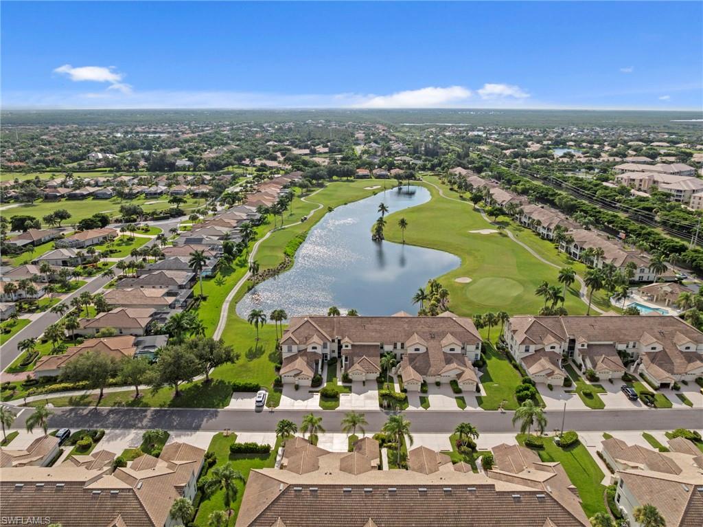 Golf course community featuring multiple residential buildings, a central lake, and mature landscaping
