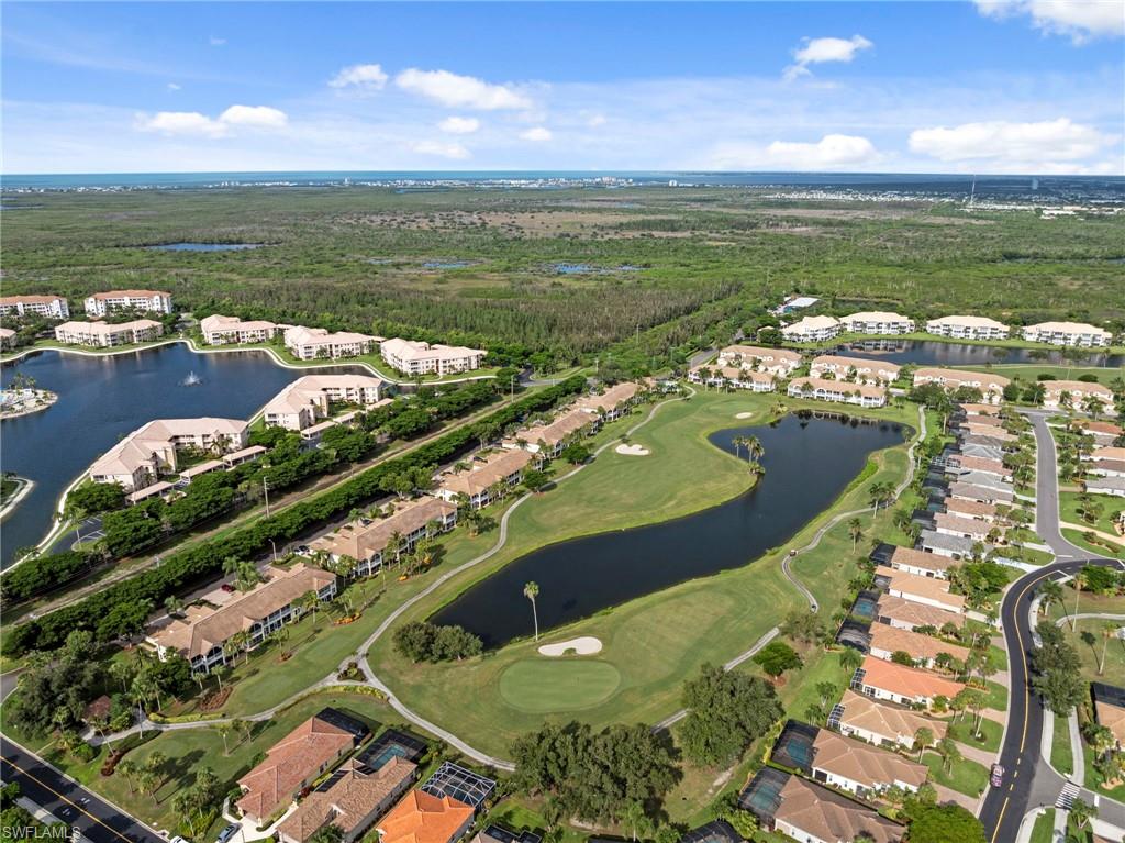 Aerial perspective showcasing a residential community with golf course frontage, multiple water features, and lush landscaping