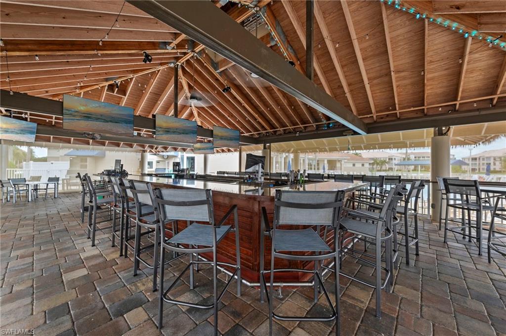 Expansive outdoor bar area featuring a wood-beam vaulted ceiling and integrated lighting