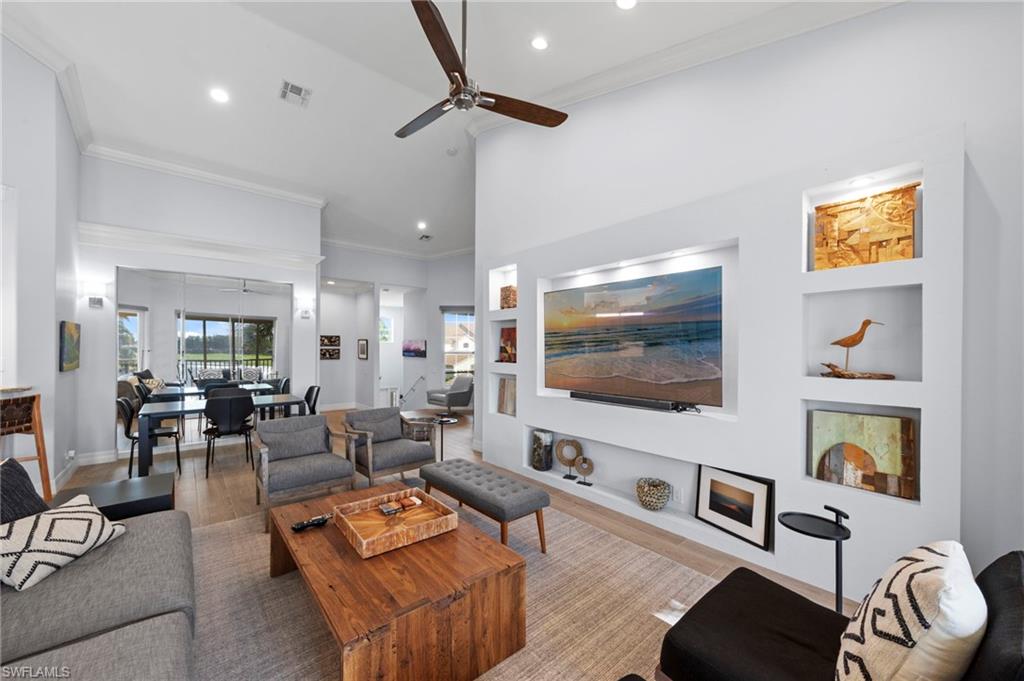 Open-concept living area featuring soaring ceilings with ceiling fan, recessed lighting, and abundant natural light from multiple windows