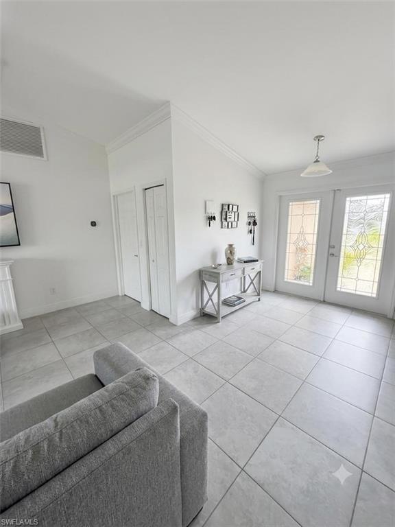 Bright and open foyer featuring tile flooring, recessed lighting, and glass French doors with sidelights providing natural illumination