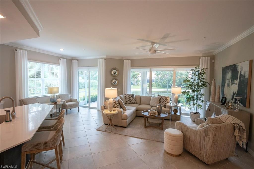 Open-concept living space featuring abundant natural light from multiple sliding glass doors and transom windows, tile flooring throughout, and a seamless layout connecting the living and dining areas