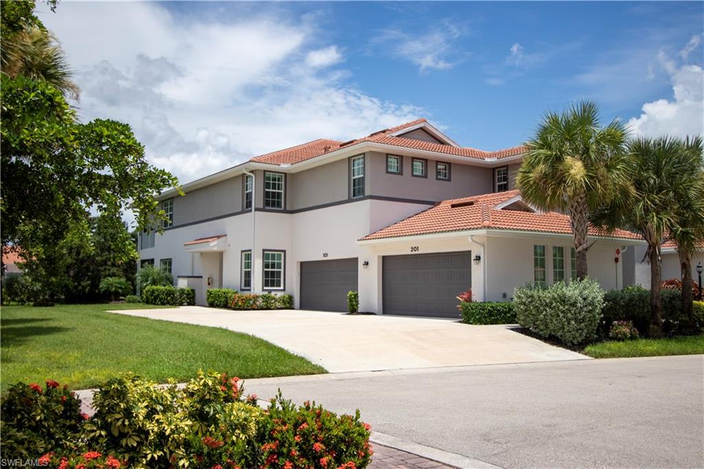 Mediterranean-style residence featuring a terracotta tile roof, stucco exterior, multiple window styles, and a two-car garage