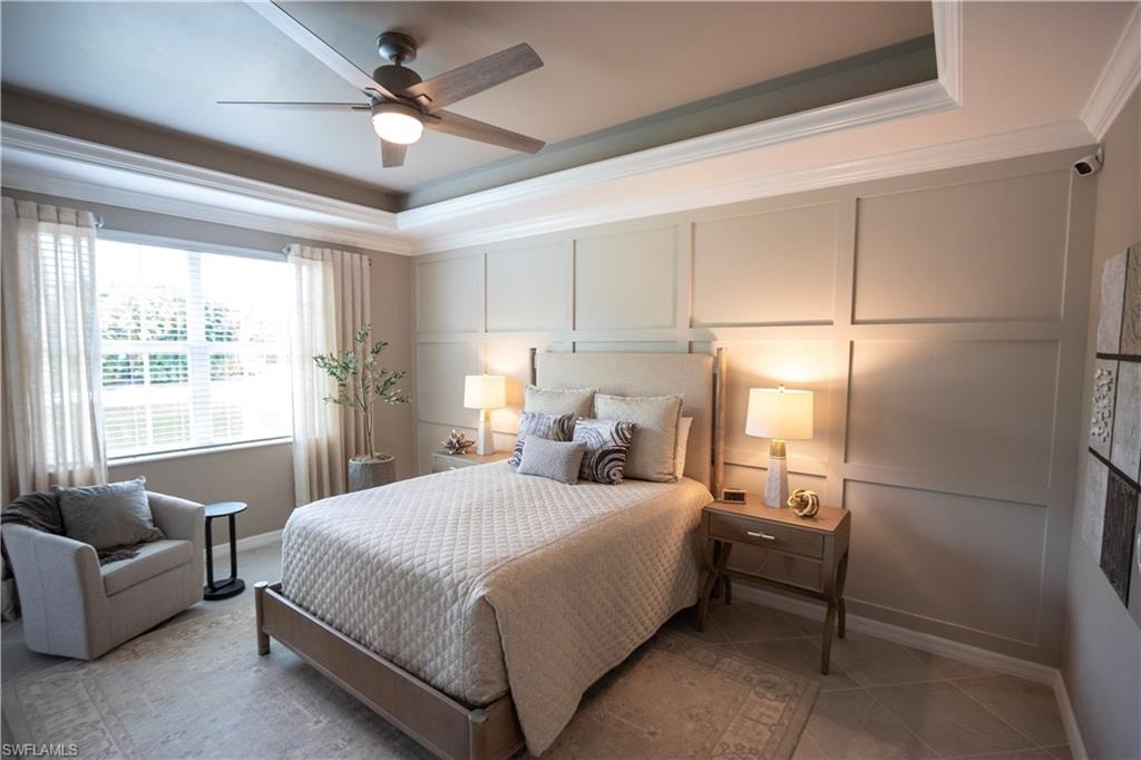 Serene primary bedroom showcasing a coffered ceiling with recessed lighting, upholstered wall paneling in soft neutral tones, hardwood-finish flooring, and an en-suite nightstand with integrated task lighting