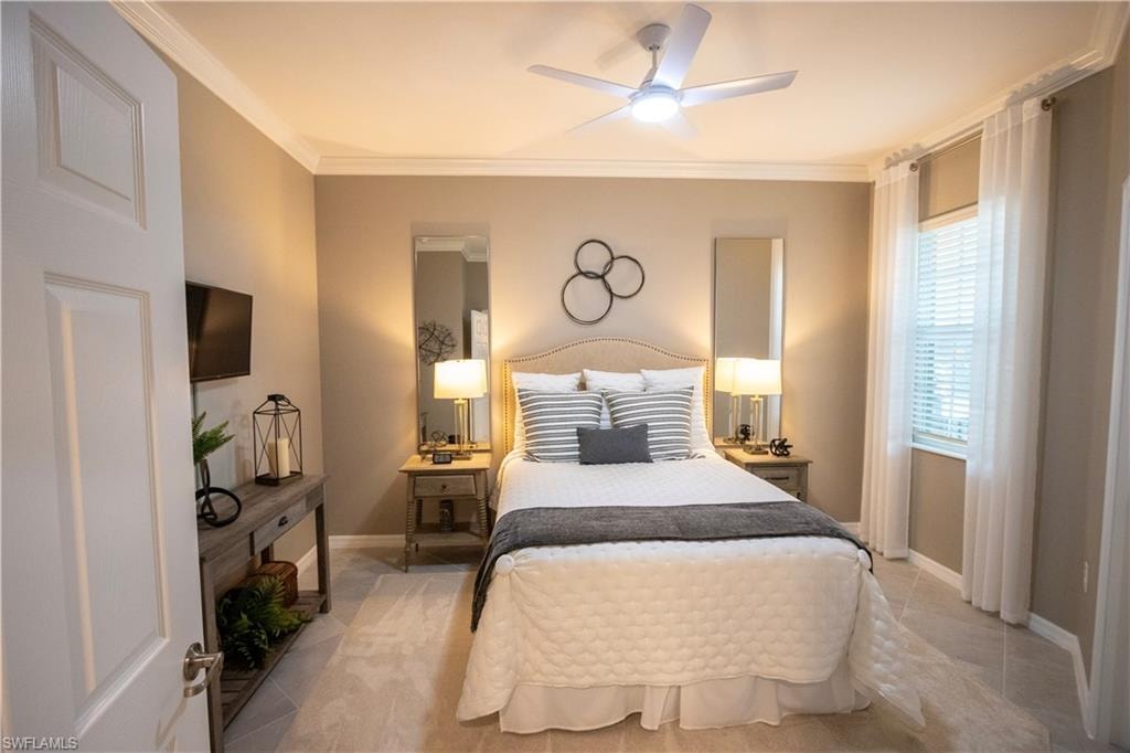 Serene primary bedroom featuring a neutral color palette, dual nightstands with integrated lighting, striped upholstered headboard, and ceiling fan