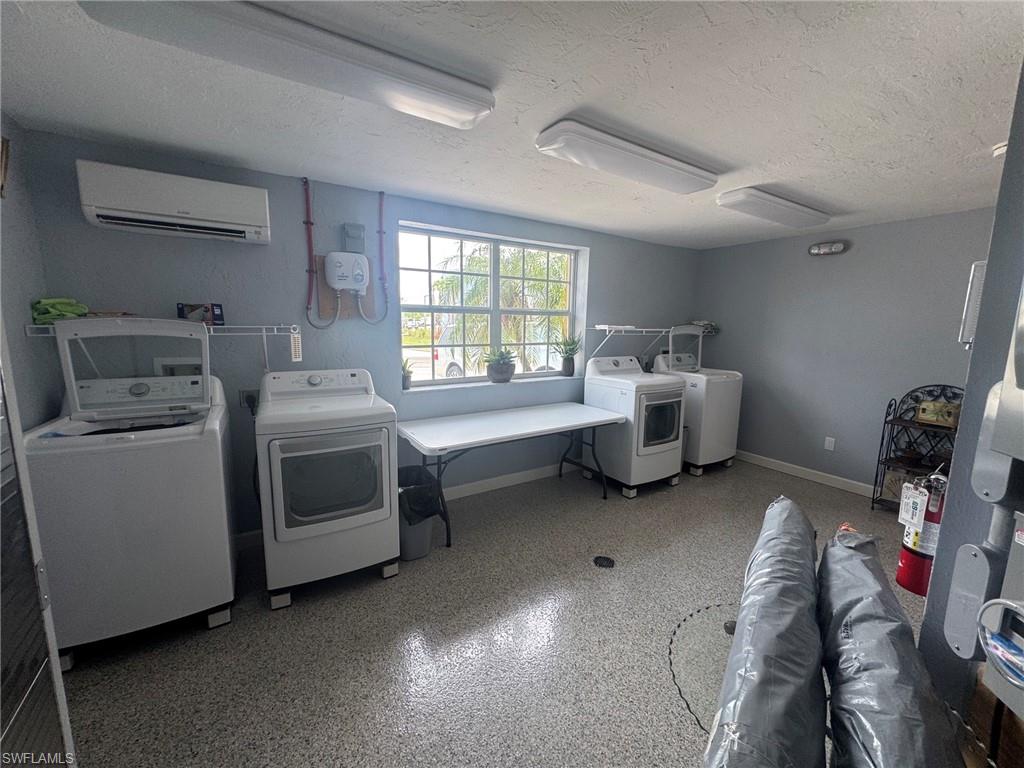 Utility room featuring light gray walls and speckled epoxy flooring
