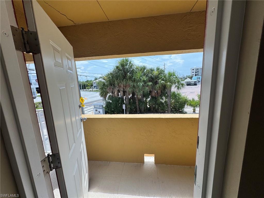 Private balcony with tile flooring and a yellow-painted exterior wall