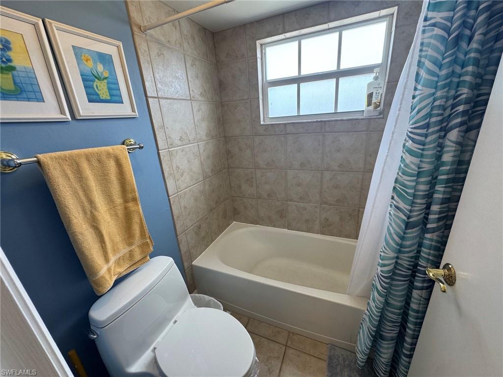 Bathroom featuring a built-in tub and shower combination with full tile surround