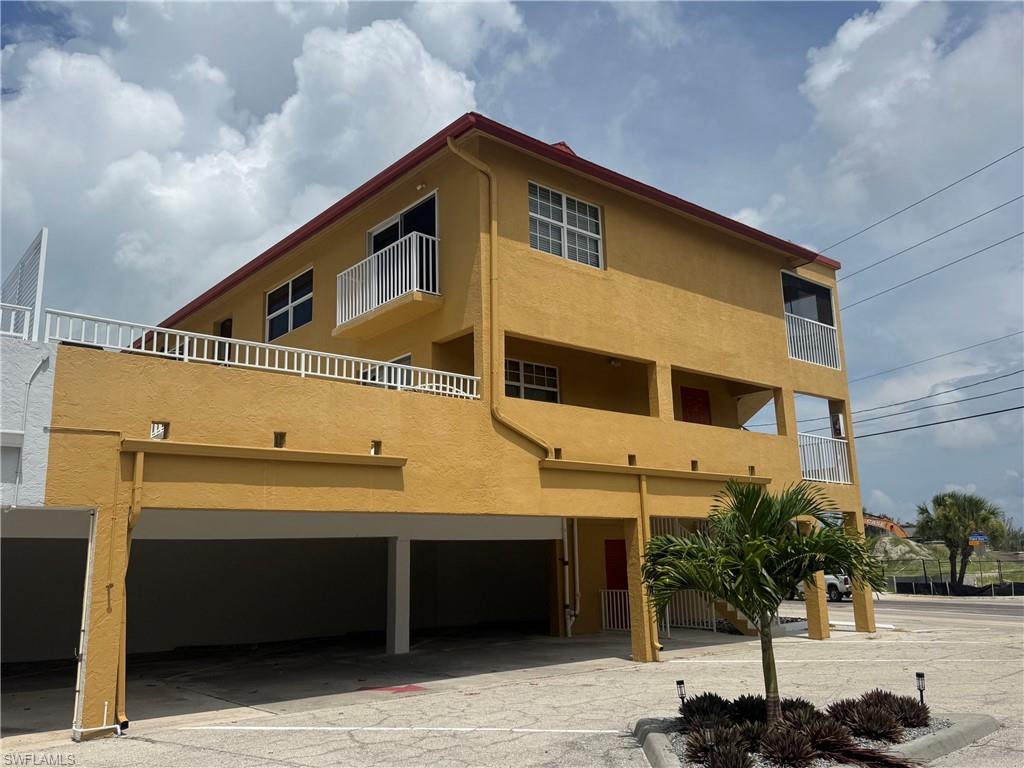 Two-story stucco property featuring  multiple balconies