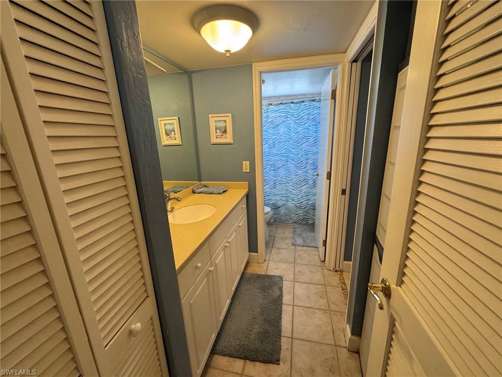 Bathroom vanity featuring a single sink, light-colored countertop, and white cabinetry