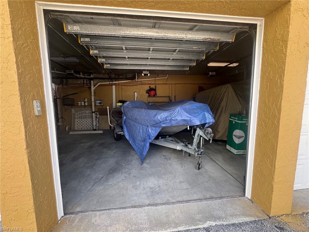 Spacious garage featuring a concrete floor, overhead lighting, and ample storage capacity