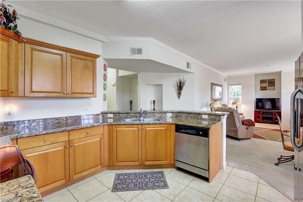Warm wood cabinetry and granite countertops define this well-appointed kitchen, featuring stainless steel appliances, tile flooring, and an island layout that anchors the space