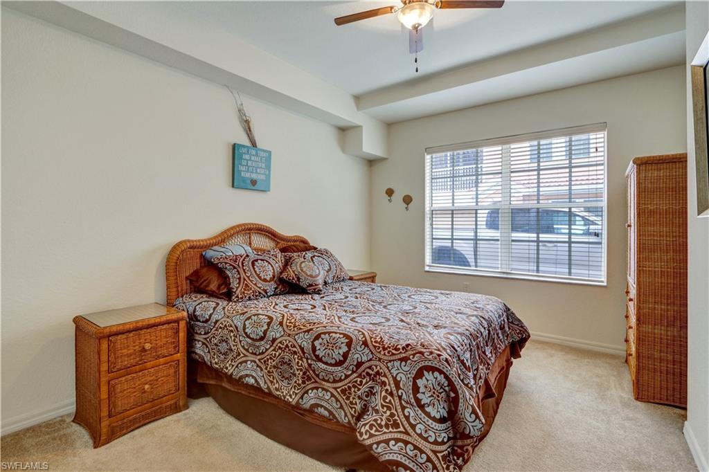 Bedroom featuring light wall color, carpet flooring, a window with horizontal blinds, and a ceiling fan with integrated lighting