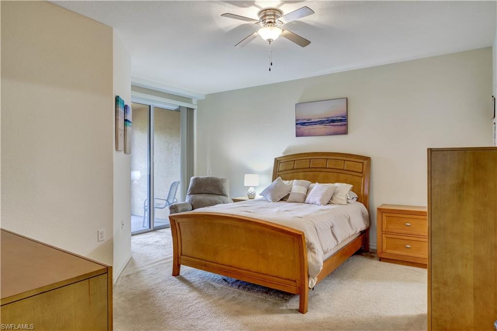 Spacious primary bedroom featuring a wood-frame bed with arched headboard, dual wood nightstands with integrated lighting, and expansive carpeted flooring