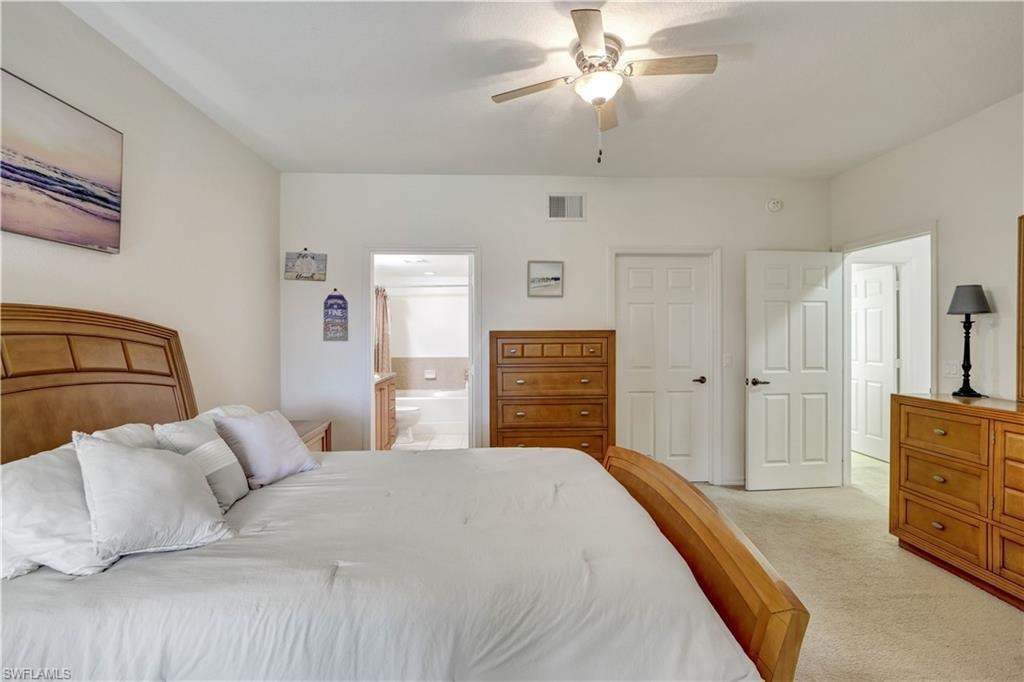 Spacious primary bedroom featuring a wood-frame bed, soft white bedding, and plush pillows