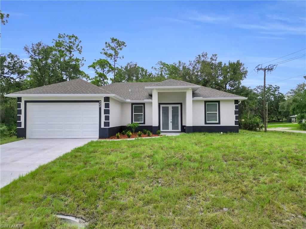 View of front of home featuring a front yard, stucco siding, a garage, concrete driveway, and a shingled roof