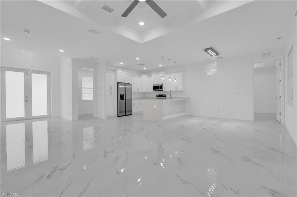 Unfurnished living room featuring coffered ceiling, beamed ceiling, recessed lighting, light marble finish floors, and ceiling fan