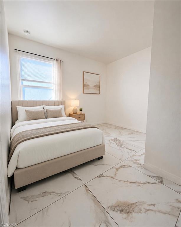 White walls, large format tile flooring with veining, and a window with blinds
