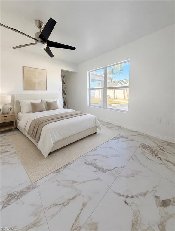 Spacious room featuring large format tile flooring, a wide window, and a ceiling fan