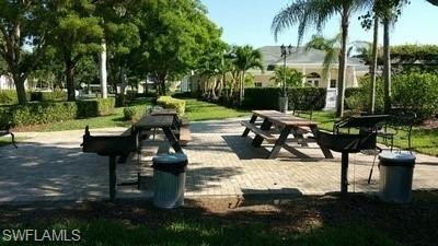 Outdoor recreation area featuring two picnic tables and two permanent grills on a paver patio
