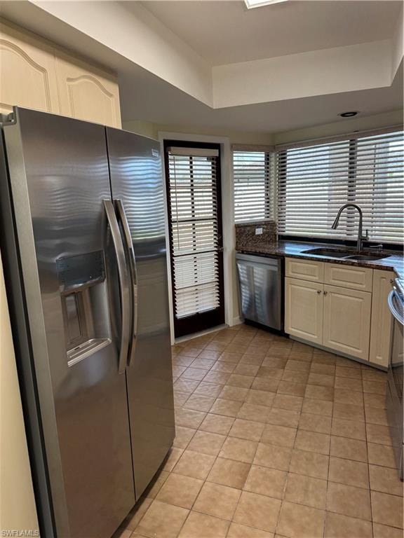 Spacious kitchen featuring stainless steel side-by-side refrigerator with ice and water dispenser, black granite countertops, and a prep sink with pull-down faucet