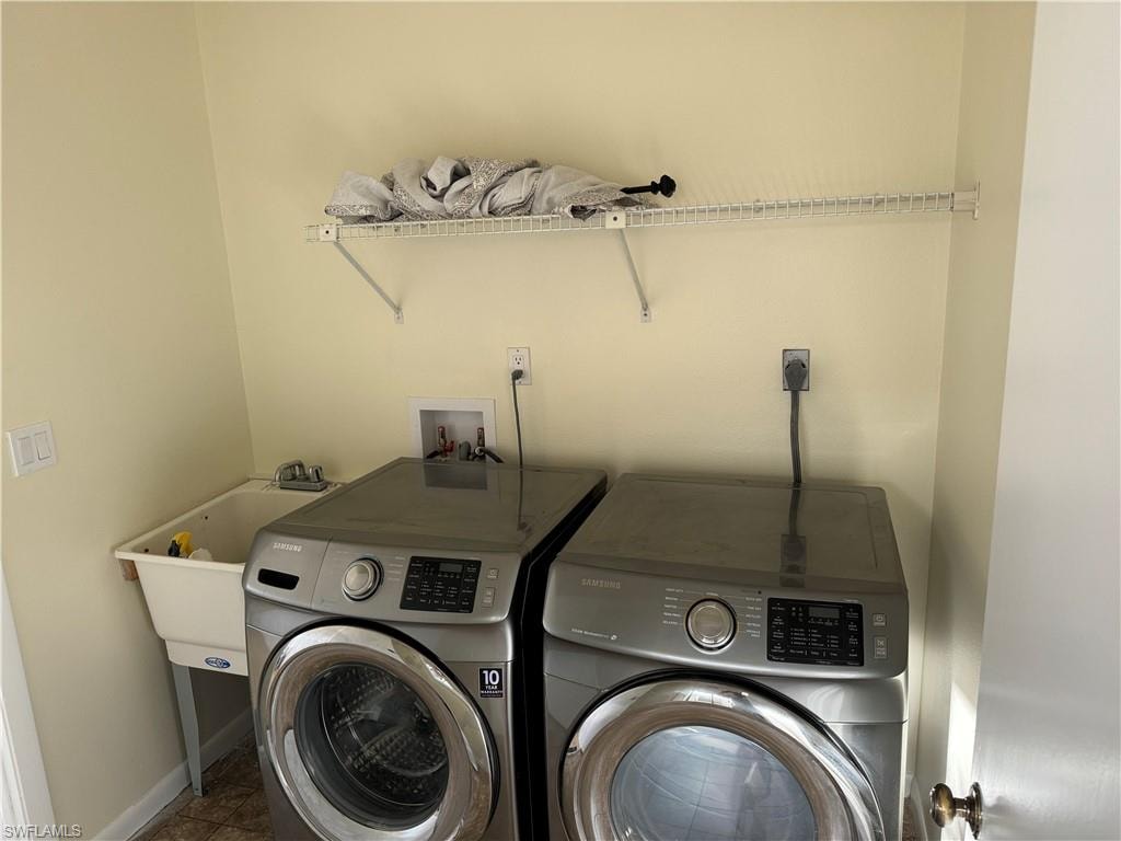 Dedicated laundry room featuring side-by-side stainless steel front-load washer and dryer with digital controls, wood-finish flooring, wall-mounted shelving with storage capacity, and dedicated electrical outlets for appliance operation