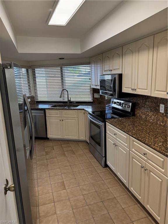 Modern kitchen featuring cream cabinetry with ample storage, granite countertops, and stainless steel appliances including double wall ovens and a gas cooktop