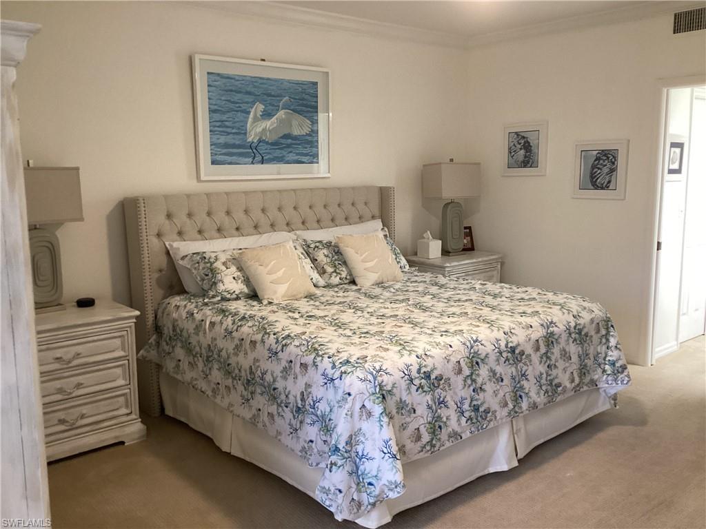 Bedroom with light carpet and ornamental molding