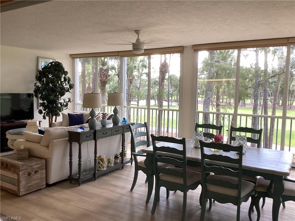 Enclosed lanai with a textured ceiling, wood finished floors, and expansive windows