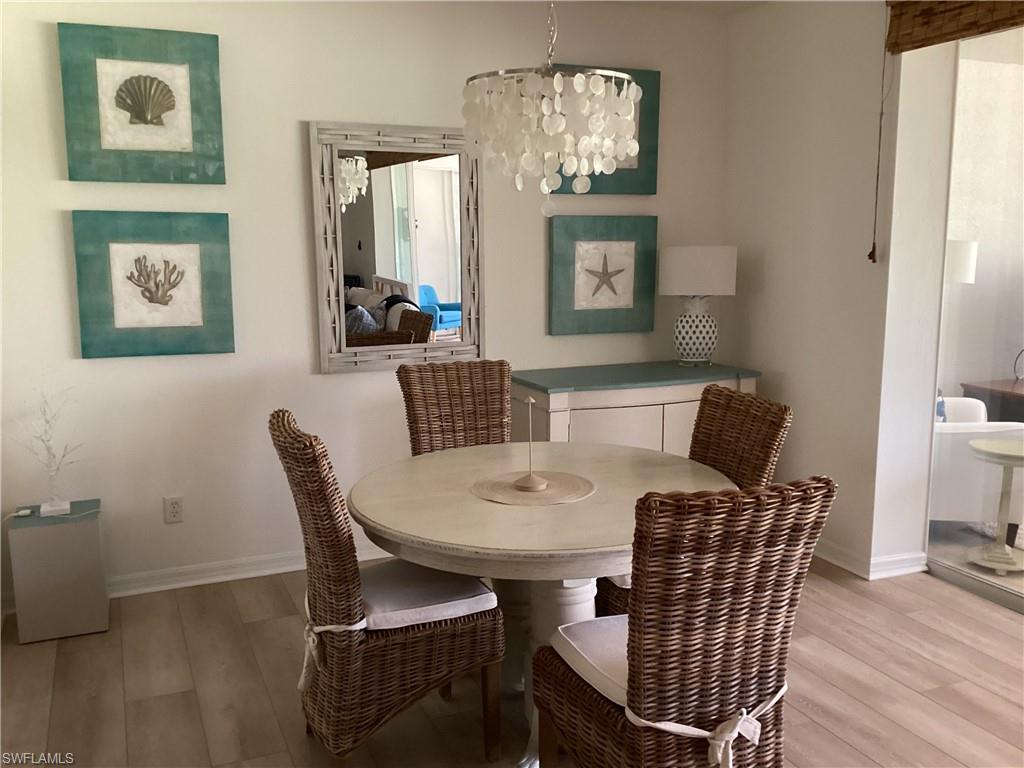 Dining room with light wood-type flooring and a chandelier