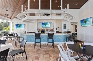 Dining room featuring a high ceiling, a ceiling fan, and a decorative wall
