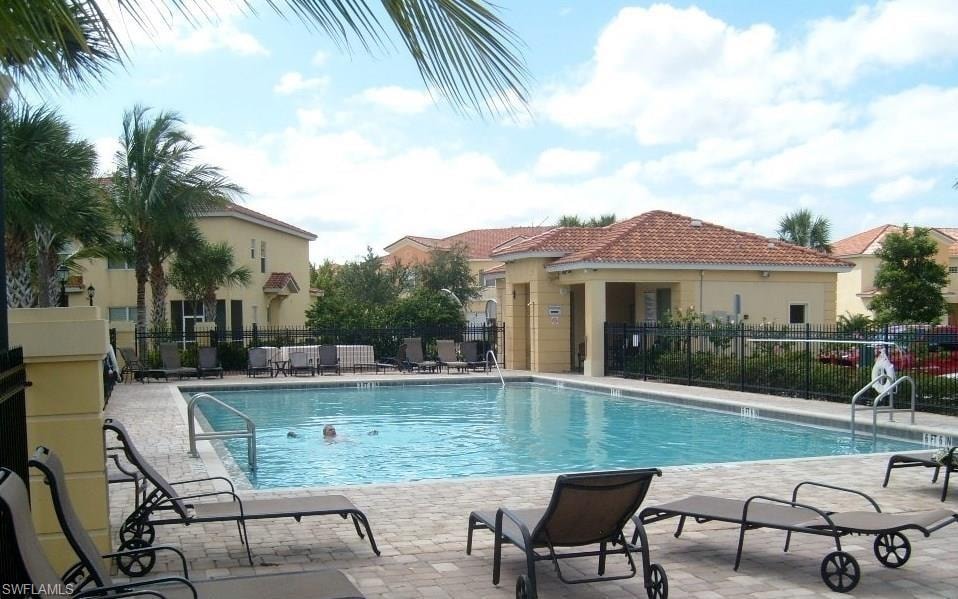 Outdoor swimming pool with integrated steps and handrails, surrounded by a paver deck