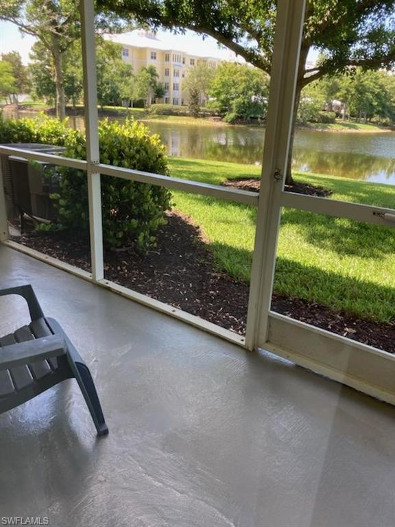 Screened porch with textured concrete flooring offering expansive water frontage, manicured landscaping, and mature trees