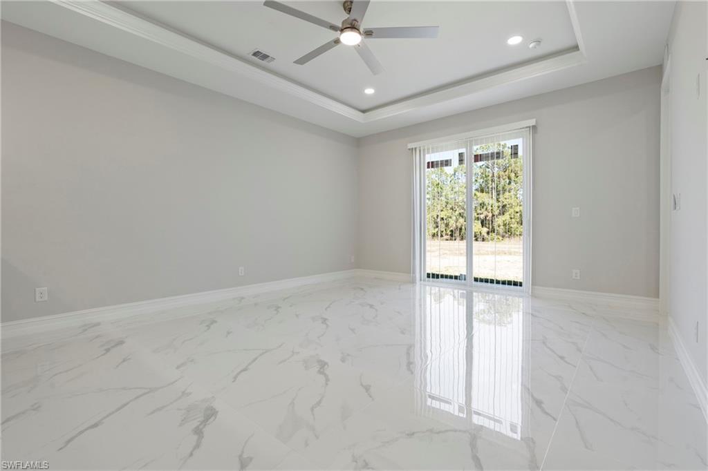 Unfurnished room with marble finish floor, visible vents, a tray ceiling, and recessed lighting