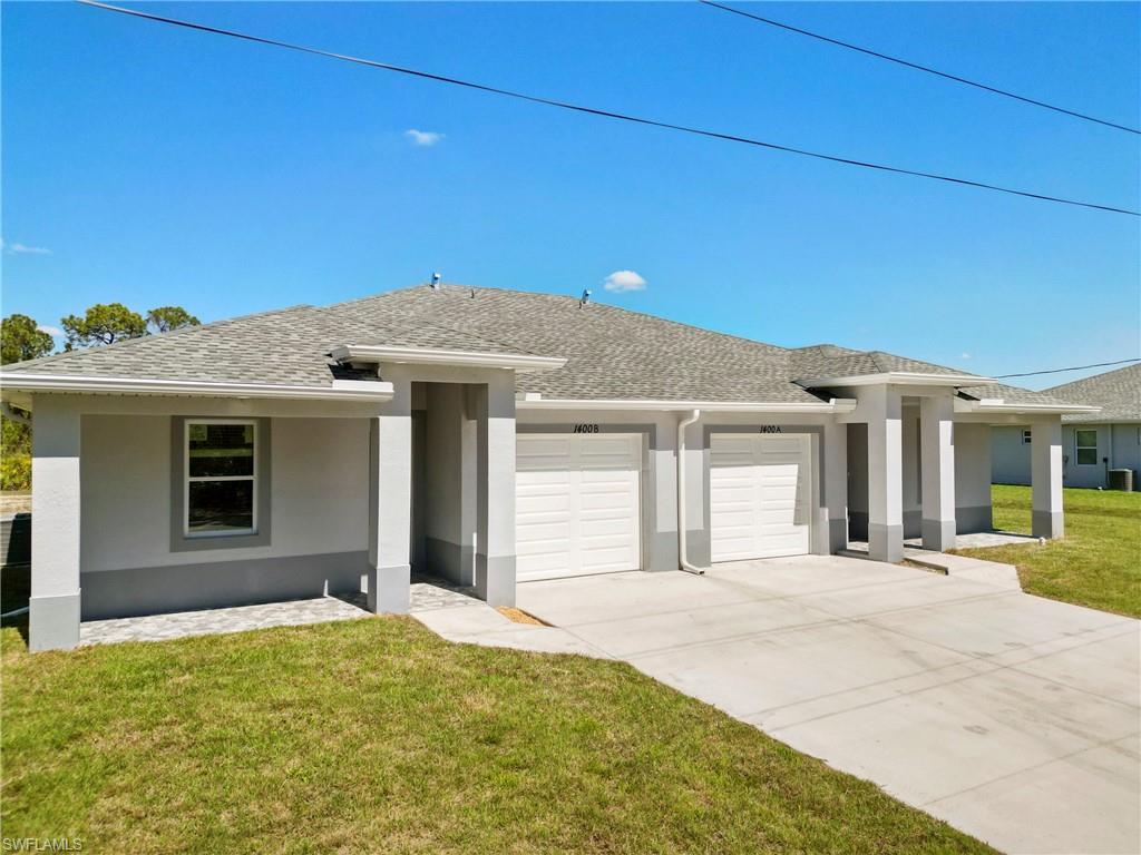 Prairie-style house with driveway, a shingled roof, stucco siding, an attached garage, and a front yard