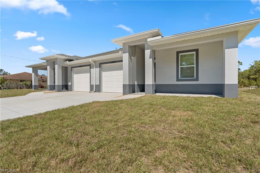 Prairie-style home with concrete driveway, stucco siding, an attached garage, and a front yard