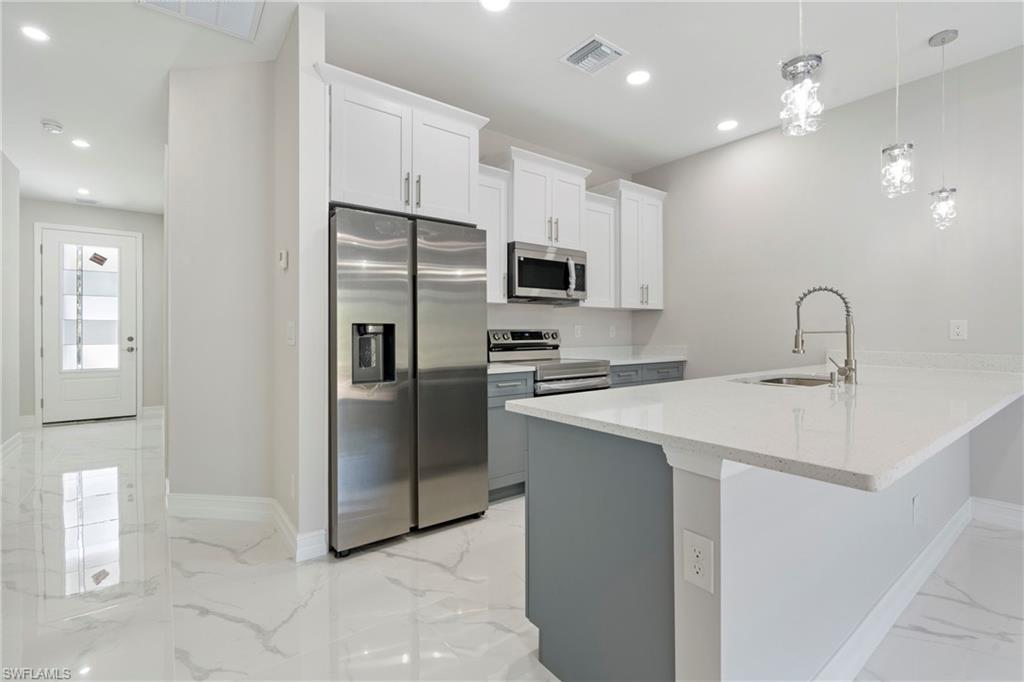 Kitchen featuring marble finish floor, recessed lighting, visible vents, appliances with stainless steel finishes, and a sink