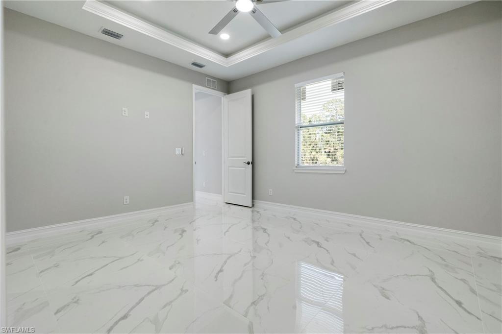 Spare room featuring visible vents, a raised ceiling, ceiling fan, marble finish floor, and recessed lighting