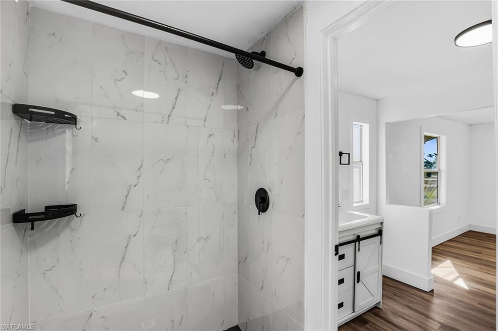 Shower stall featuring large format marbled wall tiles and matte black fixtures