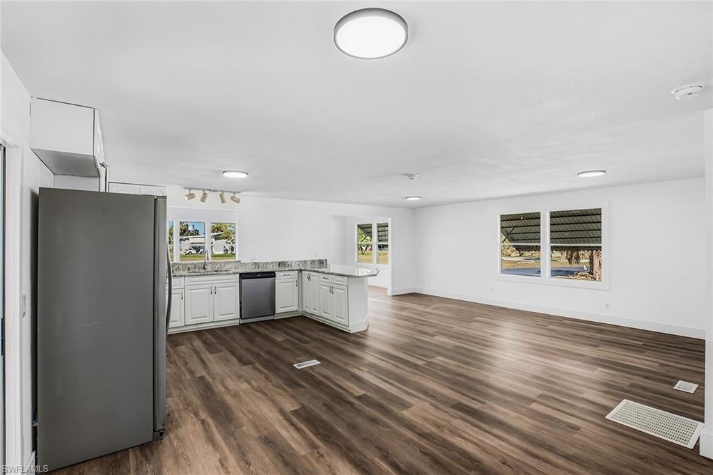 Open-concept living space featuring wood-finish flooring, white walls, and recessed lighting