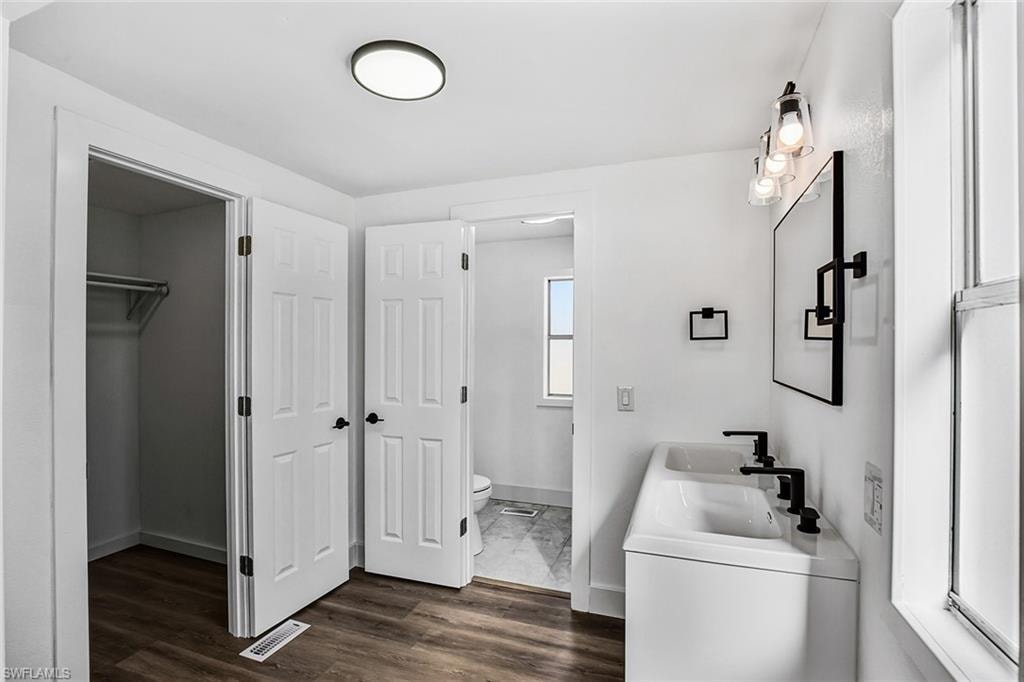 Dual vanity with matte black fixtures and a contemporary wall-mounted light fixture