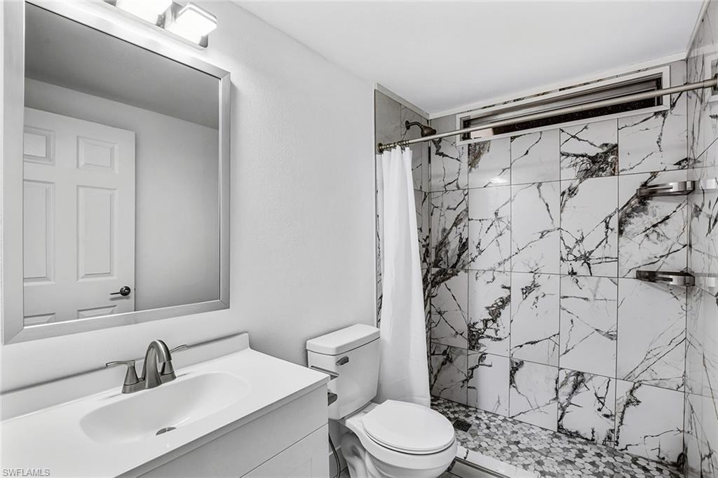 Contemporary bathroom featuring a white vanity with integrated sink, brushed nickel faucet, and a framed mirror